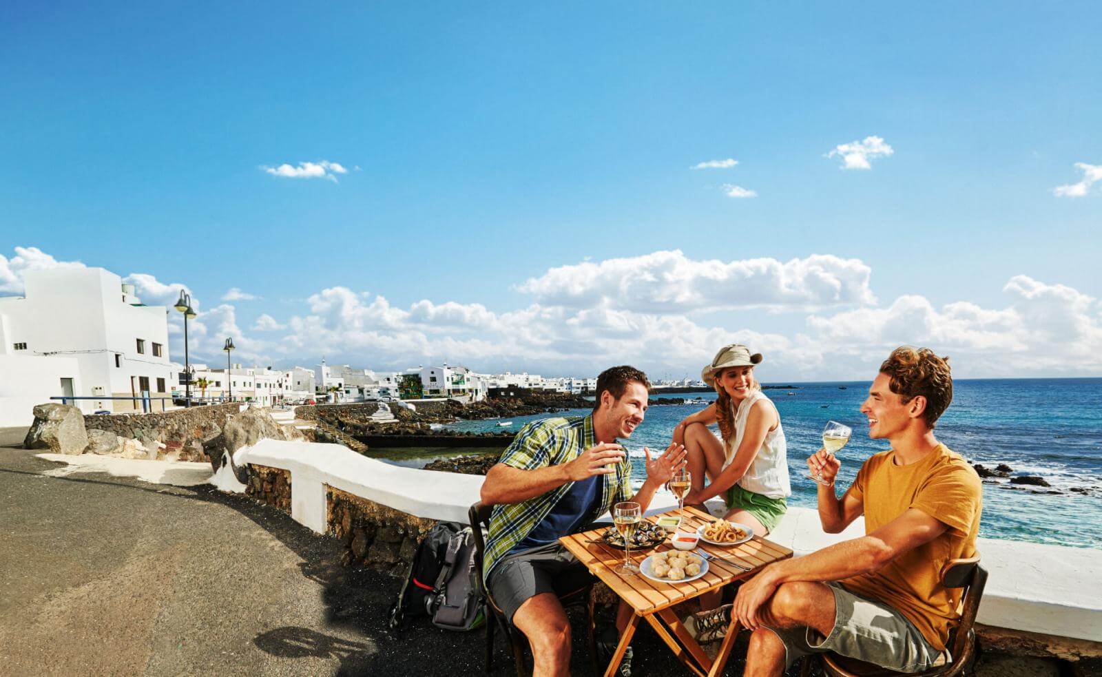 Grupo de amigos de tapas en paseo marítimo 